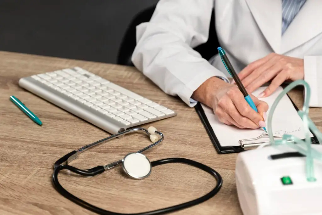 high-angle-female-physician-writing-prescription-desk